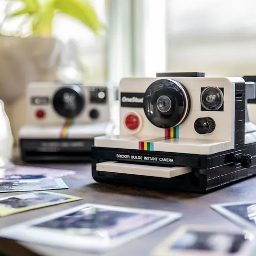 An instant camera built from bricks, on a desk