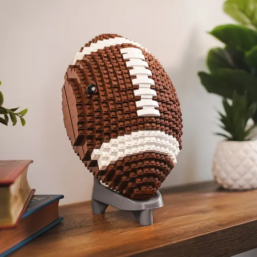 An American football built from bricks, displayed on a desk